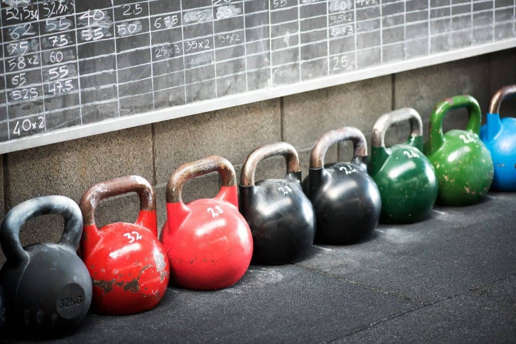 Row Of Colorful Kettlebell Weights In A Gym