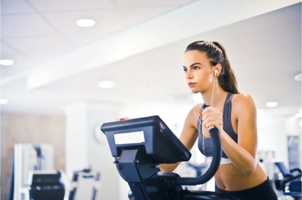 A woman running on a treadmill to maintain fitness levels